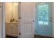 Well-lit bathroom with stylish vanity and a glimpse of the bright, inviting front door at 474 Pine Ridge Rd, Zebulon, NC 27597