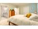 Bright bedroom with a wooden dresser and a view to the bathroom with white cabinets and countertop at 474 Pine Ridge Rd, Zebulon, NC 27597