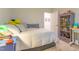 Bright bedroom with a cozy bed, white linens, and a gray bookshelf filled with decorative items at 474 Pine Ridge Rd, Zebulon, NC 27597