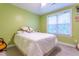 Green bedroom with a comfortable bed, floral decor, and plenty of natural light at 474 Pine Ridge Rd, Zebulon, NC 27597