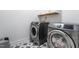 Laundry room with stainless steel washer and dryer and a tile floor with star pattern at 474 Pine Ridge Rd, Zebulon, NC 27597
