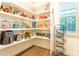Pantry with white shelves stocked with a variety of non-perishable food and appliances at 474 Pine Ridge Rd, Zebulon, NC 27597