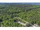 An aerial view of the home and wooded lot with mature trees that surrounds the property at 506 Burgess Rd, Apex, NC 27523