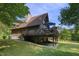 Exterior of the home with a large wrap-around deck and stone foundation at 506 Burgess Rd, Apex, NC 27523