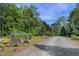 Estate entrance with a decorative gate, signage and a long gravel driveway at 506 Burgess Rd, Apex, NC 27523