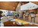 Open-concept living room flows into the kitchen, featuring a stone fireplace, wood ceilings, and bar seating at 506 Burgess Rd, Apex, NC 27523