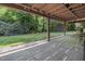 Covered patio offering shade and a view of the expansive, tree-lined backyard at 506 Burgess Rd, Apex, NC 27523