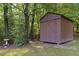 Well-maintained shed with a barn door nestled amongst mature trees at 506 Burgess Rd, Apex, NC 27523