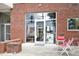 Store front with large windows and red chairs with a red brick exterior creating an inviting outdoor space at 506 N Mangum St # 402, Durham, NC 27701
