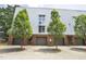 Modern townhome featuring metal siding, brick accents, individual garages and landscaped trees at 506 N Mangum St # 402, Durham, NC 27701