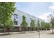 Modern building featuring symmetrical windows, tall trees, garages and a well-maintained street at 506 N Mangum St # 402, Durham, NC 27701