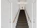 Bright stairway with brown carpet, white walls, and wooden handrail leading upwards with visible fire extinguisher at 506 N Mangum St # 402, Durham, NC 27701