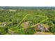Aerial view of a private estate with a brick home surrounded by lush green trees and a yellow property line at 5250 Sartin Rd, Burlington, NC 27217