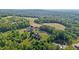 A beautiful property featuring multiple homes and a pond surrounded by vast greenery and open space at 5250 Sartin Rd, Burlington, NC 27217