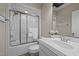 Well-lit bathroom featuring a shower with sliding glass doors, a white vanity, and a decorative floral arrangement at 5250 Sartin Rd, Burlington, NC 27217