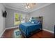 Comfortable bedroom featuring hardwood floors, a stylish wood bedframe, and a window that brings in natural light at 5250 Sartin Rd, Burlington, NC 27217