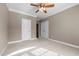 A bedroom with a ceiling fan, neutral-colored carpet, and two doors leading to other areas of the house at 5250 Sartin Rd, Burlington, NC 27217