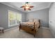 Cozy bedroom with a wood-framed bed, a window with blinds, and carpet flooring, illuminated by a ceiling fan at 5250 Sartin Rd, Burlington, NC 27217