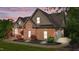 A charming brick home featuring an attached garage and meticulously manicured landscaping create great curb appeal at 5250 Sartin Rd, Burlington, NC 27217