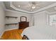 A main bedroom with hardwood floors, a ceiling fan, dresser and mirror, and access to the main bathroom at 5250 Sartin Rd, Burlington, NC 27217