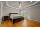 A main bedroom with hardwood floors, a ceiling fan, and large window letting in natural light at 5250 Sartin Rd, Burlington, NC 27217