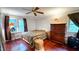 Bedroom with hardwood floors, ceiling fan, and large window at 5728 Carriagehouse Ct, Apex, NC 27539