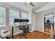 Home office with three windows, hardwood floors, and a standing desk at 5909 Royal Coach Ct, Raleigh, NC 27612