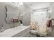 This bathroom features a floral shower curtain, decorative mirror, and marble countertops at 60 Consella Way, Franklinton, NC 27525