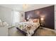 A cozy bedroom with a floral comforter, elegant lighting, and a plum accent wall at 60 Consella Way, Franklinton, NC 27525