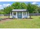 Charming front view of building with eye-catching turquoise door, stately columns, and lush green lawn at 60 Consella Way, Franklinton, NC 27525