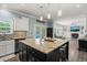 Open kitchen view with a large granite island and seating, flowing into the living room with a fireplace at 60 Consella Way, Franklinton, NC 27525
