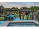 Backyard bar and lounge area with colorful seating, a fire pit, and stylish decor, illuminated by string lights at 60 Consella Way, Franklinton, NC 27525