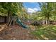 Backyard featuring a playset, storage shed, and mature trees providing ample shade at 600 Longleaf Dr, Chapel Hill, NC 27517