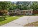 The exterior showcases a long driveway and lush lawn, complemented by a mix of brick and siding at 600 Longleaf Dr, Chapel Hill, NC 27517