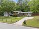 Inviting home with a long driveway leading to a detached garage, surrounded by a lush green lawn and mature trees at 600 Longleaf Dr, Chapel Hill, NC 27517