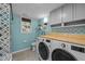 Modern laundry room features an LG washer/dryer, bright blue walls, and wood countertop at 600 Longleaf Dr, Chapel Hill, NC 27517