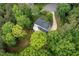 An overhead view shows the home with a deck that is surrounded by lots of mature trees at 7000 Millstone Ridge Ct, Raleigh, NC 27614