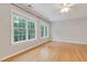 Spacious bedroom with hardwood floors, natural light from large windows, and a ceiling fan at 7000 Millstone Ridge Ct, Raleigh, NC 27614