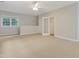 Large open bonus room with neutral walls and carpet with multiple windows and doorways at 7000 Millstone Ridge Ct, Raleigh, NC 27614