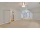 Large bonus room with neutral walls and carpet with multiple windows and ceiling fans at 7000 Millstone Ridge Ct, Raleigh, NC 27614