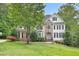 Beautiful home showcasing stone accents, a well-manicured lawn, and mature trees providing shade at 7000 Millstone Ridge Ct, Raleigh, NC 27614
