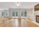 Bright living room with a fireplace, hardwood floors, and French doors leading to the patio at 7000 Millstone Ridge Ct, Raleigh, NC 27614