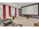 A well-lit living room featuring a large projection screen, red curtains, and a comfortable leather seating area at 7000 Millstone Ridge Ct, Raleigh, NC 27614