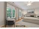 Bright bedroom featuring large windows, hardwood floors, neutral tones, and stylish modern staging at 7000 Millstone Ridge Ct, Raleigh, NC 27614