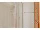 Tiled shower with glass door next to storage cabinet featuring towel rack and soap shelf at 7000 Millstone Ridge Ct, Raleigh, NC 27614