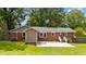 A brick exterior complemented by a well-manicured lawn and a concrete patio for outdoor enjoyment at 702 Wedgewood Ave, Zebulon, NC 27597