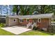 Brick exterior with a concrete patio and steps leading to the grassy backyard at 702 Wedgewood Ave, Zebulon, NC 27597
