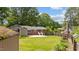 Expansive backyard with mature trees, a garden shed, and a wooden fence for privacy at 702 Wedgewood Ave, Zebulon, NC 27597