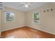 Bedroom featuring hardwood floors, two windows offering ample natural light, and neutral walls at 702 Wedgewood Ave, Zebulon, NC 27597