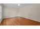 Clean bedroom with hardwood floors and neutral walls, bathed in natural light from the ceiling fan at 702 Wedgewood Ave, Zebulon, NC 27597